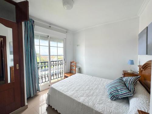 ein Schlafzimmer mit einem Bett und einem großen Fenster in der Unterkunft Casa Ana in O Grove