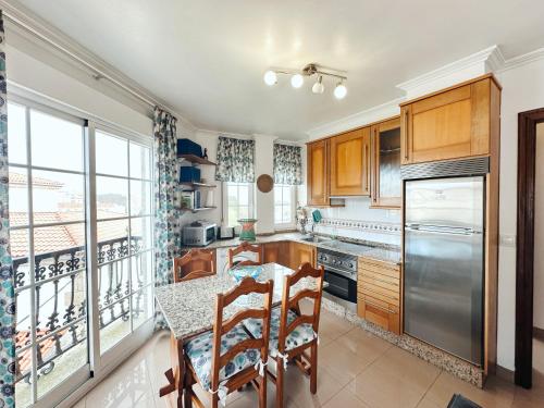 eine Küche mit Holzschränken und einem Tisch mit Stühlen in der Unterkunft Casa Ana in O Grove