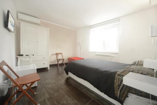 a bedroom with a bed and a desk and a window at La vita è bella - Noli in Noli