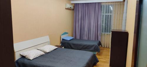 a hotel room with two beds and a window at Boulevard view spacious apartment in Baku in Baku
