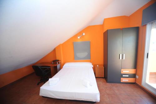 a bedroom with a bed with an orange wall at Adosado Portofino Orangecosta in Benicàssim