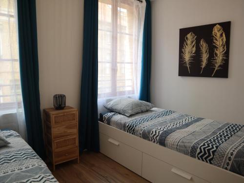 a bedroom with two beds and a window at Appartement spacieux pour 6 personnes in Saint-Omer