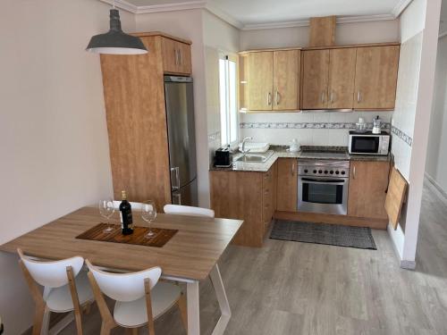 a kitchen with wooden cabinets and a table with chairs at Apartamento Fuerteventura in Puerto del Rosario