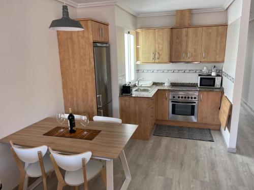 kuchnia z drewnianymi szafkami i stołem z krzesłami w obiekcie Apartamento Fuerteventura w mieście Puerto del Rosario