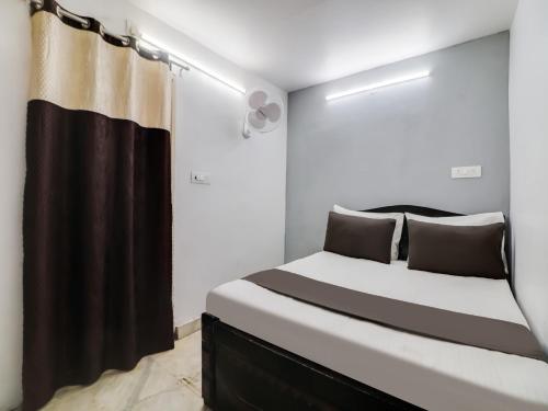 a bedroom with a bed with a black and white bedskirtspectspectspectspects at Super OYO RG Stay in New Delhi