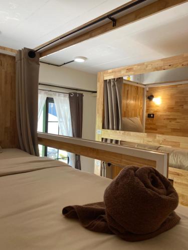 uma toalha numa cama num quarto com um espelho em Flora Hostel KhaoSok em Parque Nacional de Khao Sok