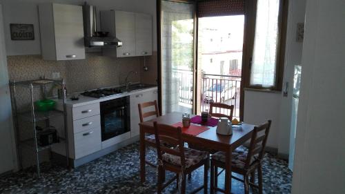 a kitchen with a table and chairs and a kitchen with a window at Casa RicAdri in Ginosa Marina