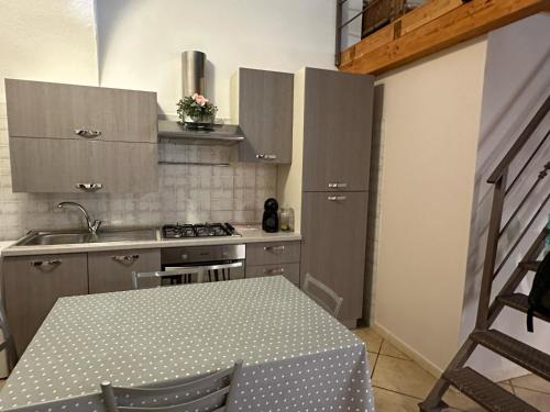 a kitchen with a table and a sink and a stove at Lūǧārah - elegante loft in centro storico in Lucera