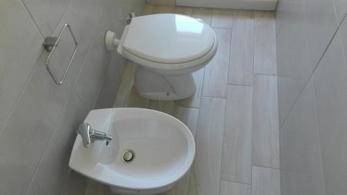a bathroom with a white toilet and a sink at Casa RicAdri in Ginosa Marina