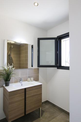 une salle de bain avec un lavabo et une fenêtre dans l'établissement LA VILLA DU BAGNAS, à Marseillan