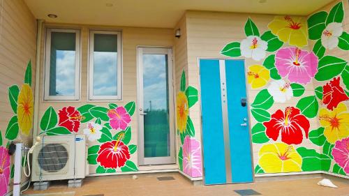 a home with a mural of flowers on the wall at Alezed Villa Shiraho in Ishigaki Island