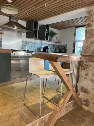 - une cuisine avec un comptoir en bois et des chaises dans l'établissement Jolie maison pleine de charme, à Orry-la-Ville