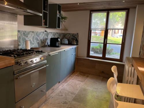 une cuisine avec une cuisinière et un comptoir dans l'établissement Jolie maison pleine de charme, à Orry-la-Ville