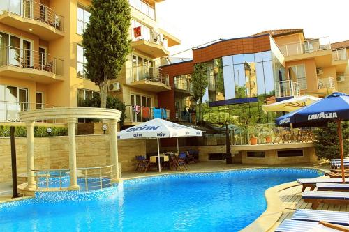 una piscina di fronte a un edificio con ombrelloni di Twins Palace ApartHotel a Sveti Konstantin i Elena