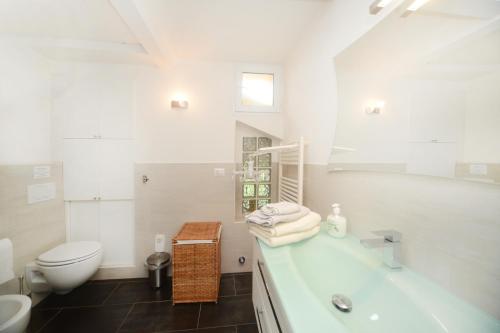 a white bathroom with a tub and a toilet at La vita è bella - Noli in Noli