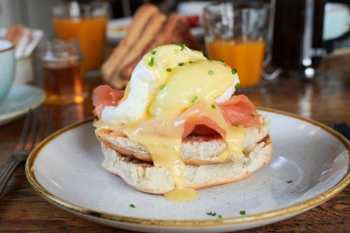 un panino con formaggio e pancetta su un piatto di Black Lion Inn a Leek