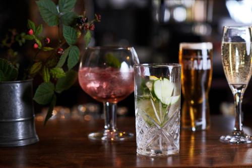 a table with three glasses of wine andbeer at Black Lion Inn in Leek