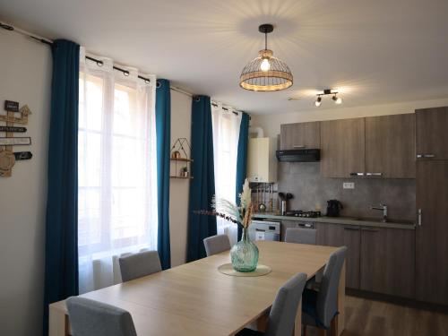 a kitchen with a wooden table with a vase on it at Appartement spacieux pour 6 personnes in Saint-Omer