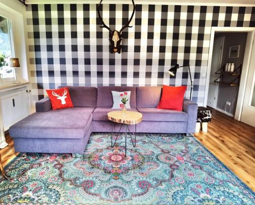 uma sala de estar com um sofá roxo e almofadas vermelhas em Melanie - b51465 em Mittenwald