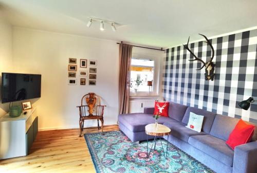 uma sala de estar com um sofá roxo e uma televisão em Melanie - b51465 em Mittenwald