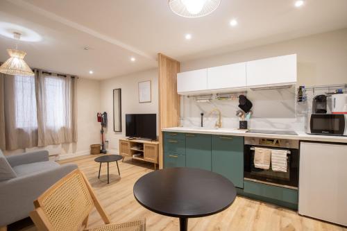 une cuisine et un salon avec un canapé et une table dans l'établissement La Venise Provençale - Hypercentre - Wifi, à LʼIsle-sur-la-Sorgue