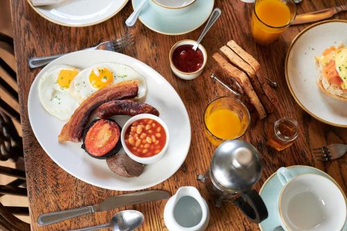 un tavolo con un piatto di prodotti per la colazione con uova e fagioli di Black Lion Inn a Leek