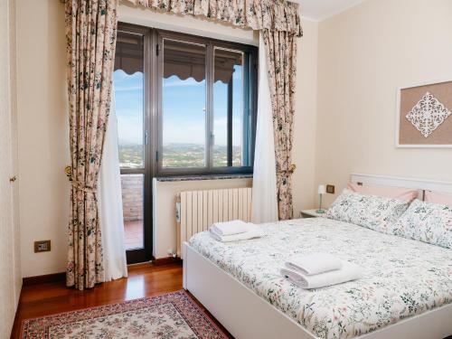 a bedroom with a bed and a large window at Yuna Rent - Villa Il Vecchio Frantoio in Chieti