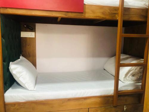a bunk bed with white sheets and a white pillow at Everest Stays Rooms and Dormitory in Mumbai