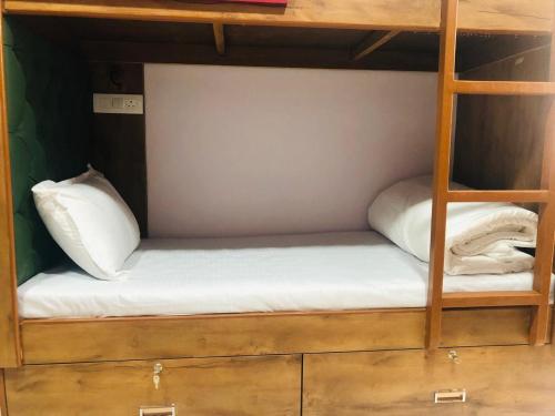 a bunk bed with two white pillows on it at Everest Stays Rooms and Dormitory in Mumbai