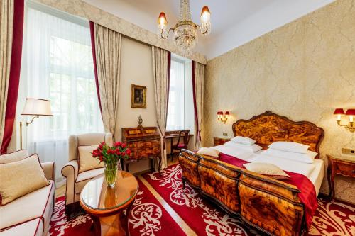 sypialnia z dużym łóżkiem i kanapą w obiekcie Hotel Stefanie - VIENNA'S OLDEST HOTEL w Wiedniu