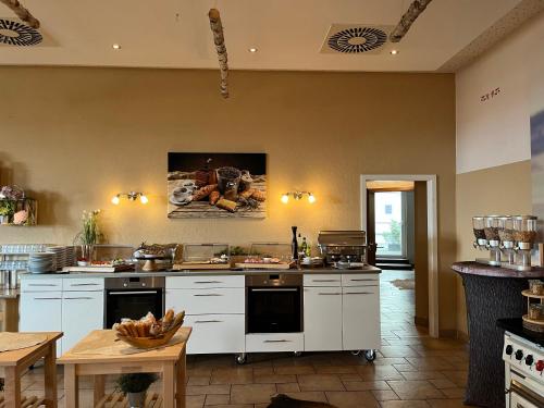 Hotel an der Burg في أوليمبياذا: مطبخ كبير مع أجهزة بيضاء وطاولة