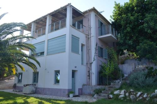 Biały dom z palmą przed nim w obiekcie Casa Muraglia Studio/Studio Under Castle w mieście Travliáta
