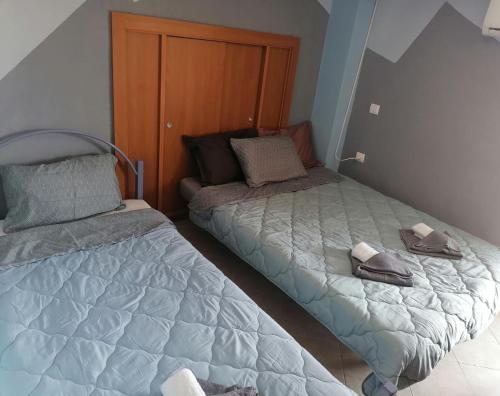 a bedroom with two beds with slippers on them at Effrosyni's House in Kanália