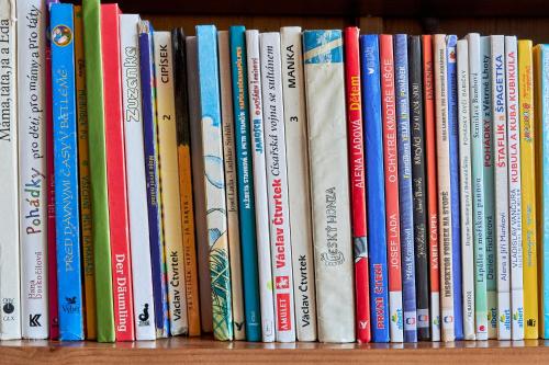 a row of books sitting on a shelf at Chata Harmonie in Bedřichov