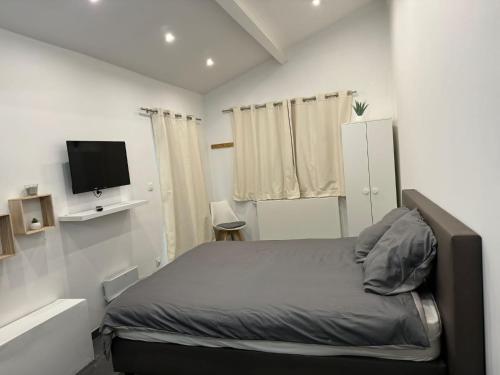 - une chambre avec un lit et une télévision à écran plat dans l'établissement Chez Antoine, à Saint-Ghislain