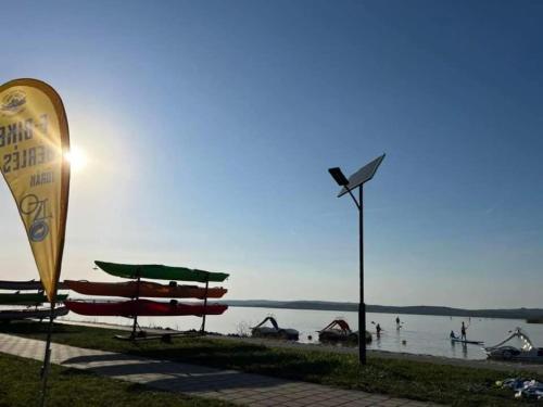 a beach with umbrellas and people in the water at Amur Vendégház in Gárdony