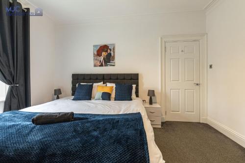 a bedroom with a bed with a blue blanket on it at River Teviot in Hawick