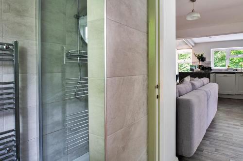 a living room with a glass shower door at Finest Retreats - Nant Cottage in Llangelynin