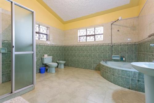 a bathroom with a tub and a toilet and a sink at GIGIRI DRIVE::2BR EXQUISITELY FURNISHED PENTHOUSE in Nairobi