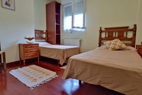 1 dormitorio con 2 camas y una mesa con galletas en el suelo en Los acebos. Mar, montaña, cuevas, en Rasines