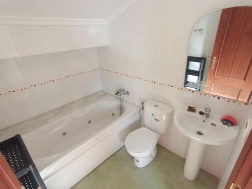 a white bathroom with a toilet and a sink at Los acebos. Mar, montaña, cuevas in Rasines