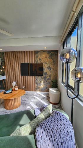 a bedroom with a bed and a table and a tv at Harbour-view Waterfront Apartment in Darwin