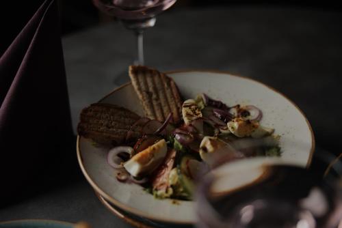 a plate of food and a glass of wine at Campanile Katowice in Katowice