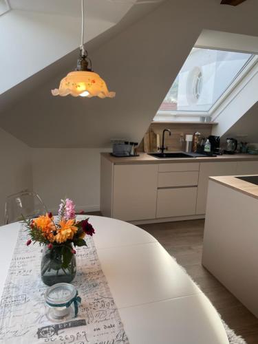 a vase of flowers on a table in a kitchen at Kerschbaumer.Apartments in Waidhofen an der Ybbs