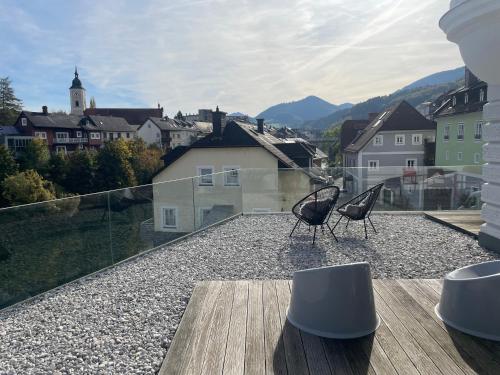 a balcony with two chairs and a view of a city at Kerschbaumer.Apartments in Waidhofen an der Ybbs