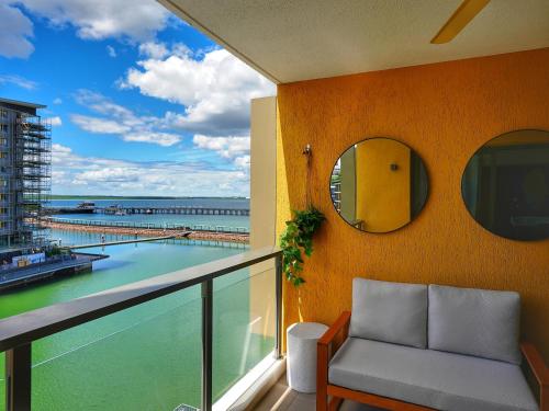 a balcony with a mirror and a view of the ocean at Wharf-view Waterfront Apartment in Darwin