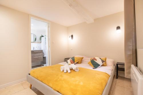 une chambre avec un lit avec deux animaux en peluche dessus dans l'établissement La Venise Provençale - Hypercentre - Wifi, à LʼIsle-sur-la-Sorgue