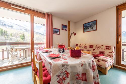 - une salle à manger avec une table, un lit et une fenêtre dans l'établissement Appartement Bdl, à Saint-François-Longchamp