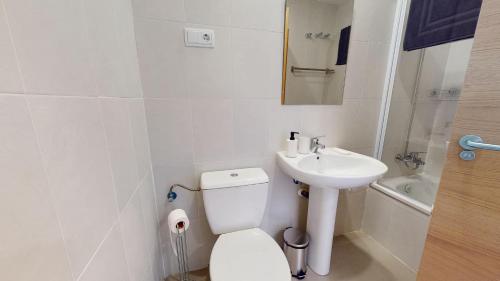 Baño blanco con aseo y lavamanos en Casa De La Sol Saurines - Brand New Apartment!, en Las Pedreñas