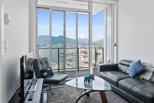 a living room with a couch and a large window at Bright and Modern Suite with Amazing views! in Vancouver